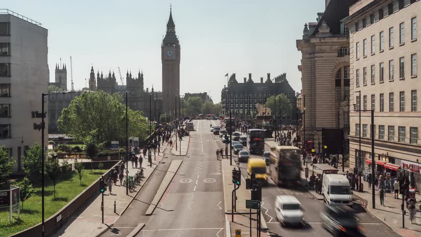 Traffic and pedestrian traffic timelaps on a street in london with big ben clocktower in the background on a sunny day