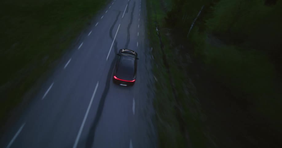 A car driving fast on an highway during dawn
