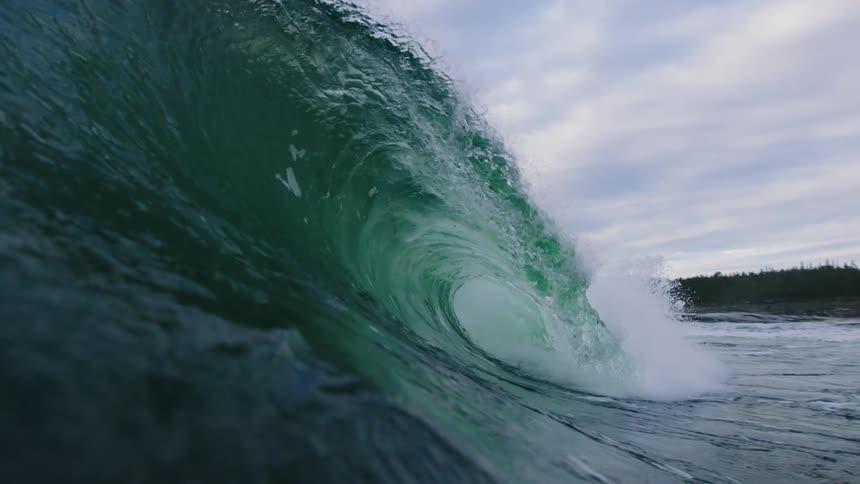 A wave curling into a tube as it heads to shore