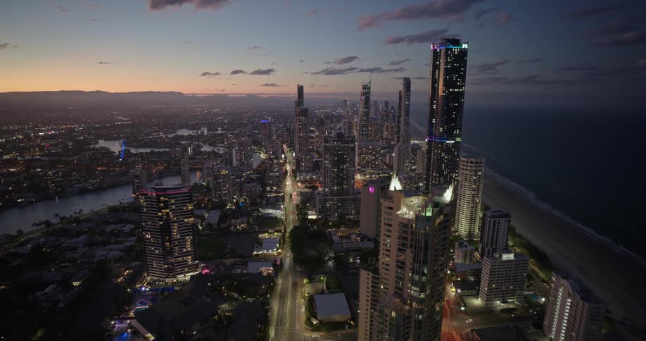 A region with many tall buildings facing the sea on a night