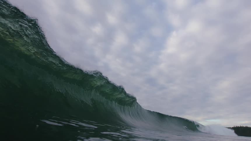 A large wave crashes in the ocean