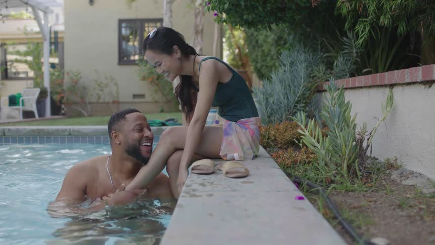 Couple in the pool playing and smiling