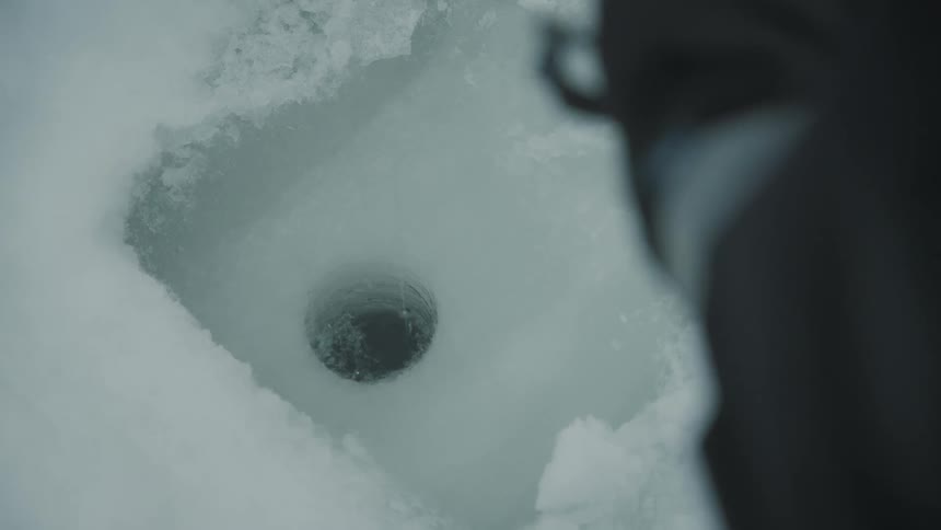 Fishing line inside a small hole in the ice