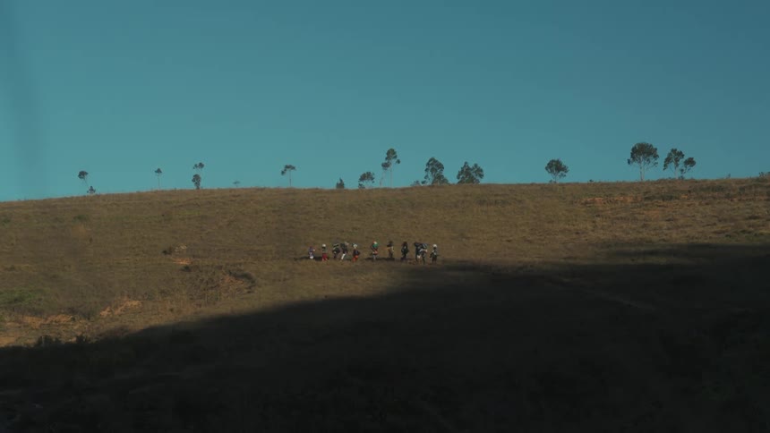 Group of people walking amidst hills on a day with clear skies