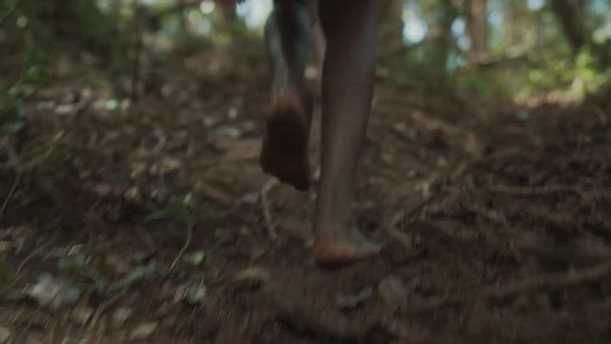 People walking barefoot through the forest