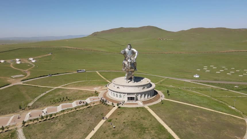 Tourists visit a large statue on a building
