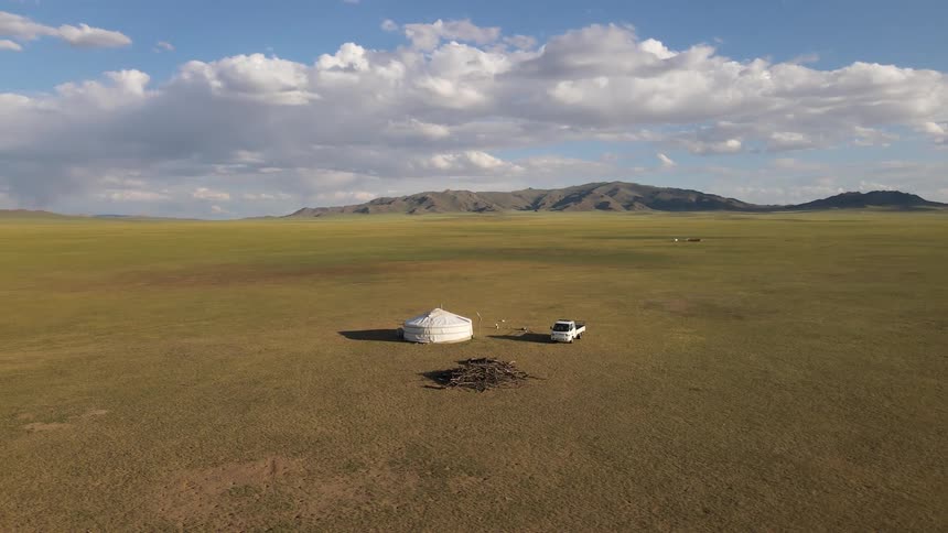 Aerial of a white tent and a van in the field