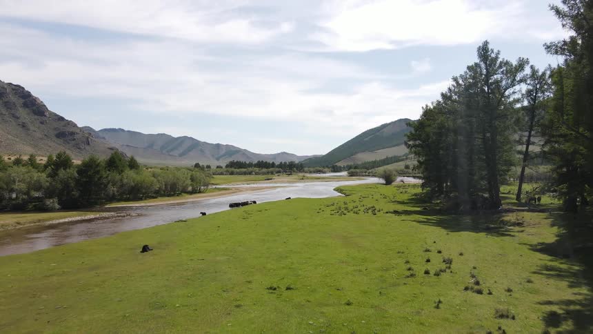 A landscape featuring a river flowing down through a green field