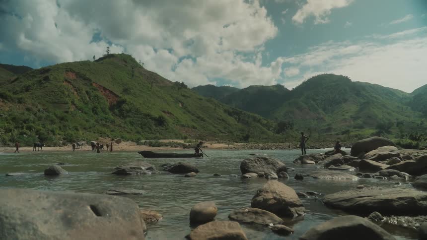 A rowboat is crossing the river