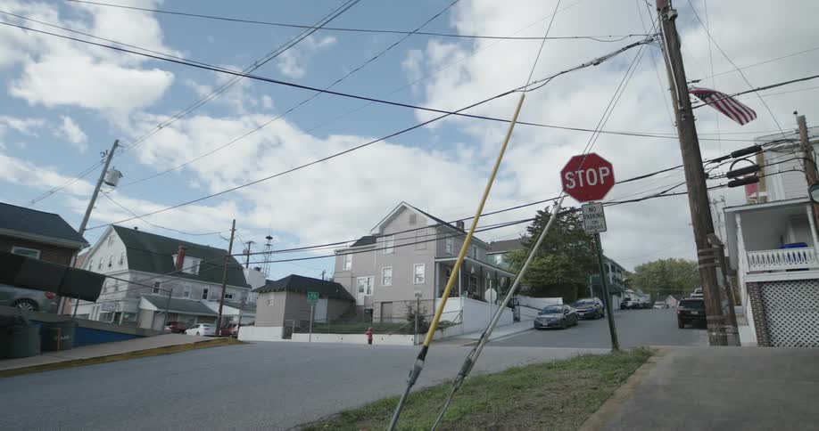 A suburban intersection with cars parked on the street on a partly cloudy day