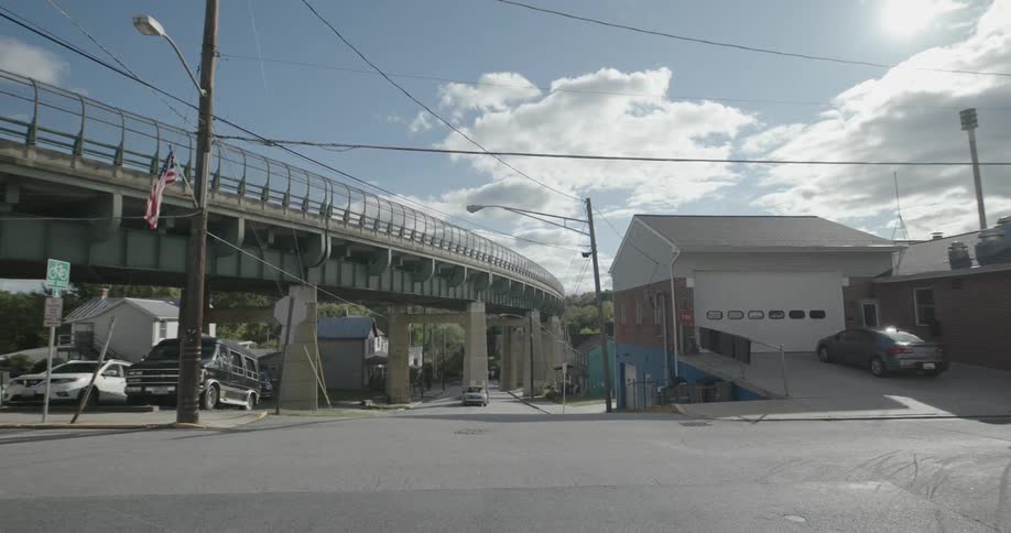 An overhead bridge in a city close to an intersection