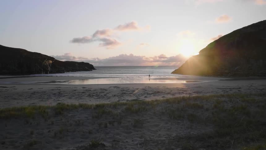 A rock beside a beach at sunrise
