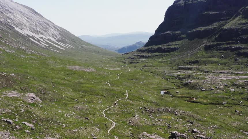 Mountaineers hiking on a path through the mountains
