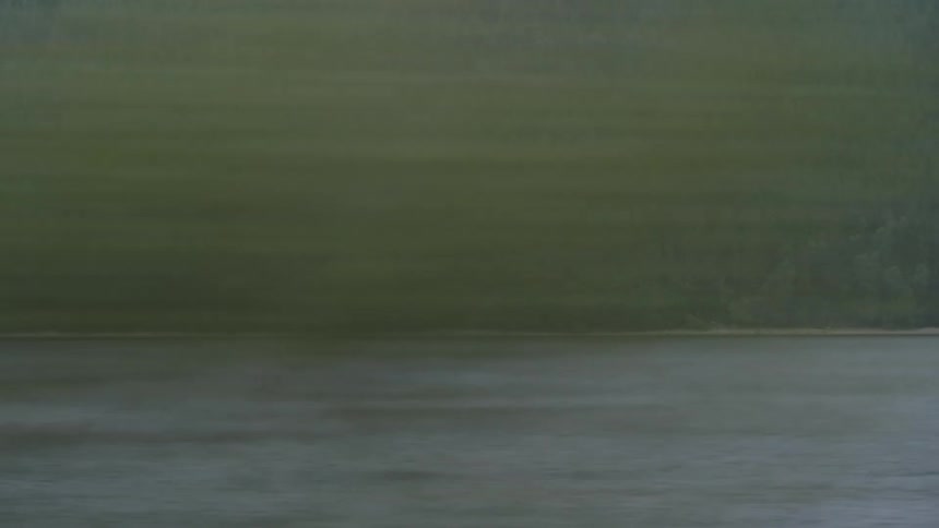 A river in the mountains seen from a moving vehicle