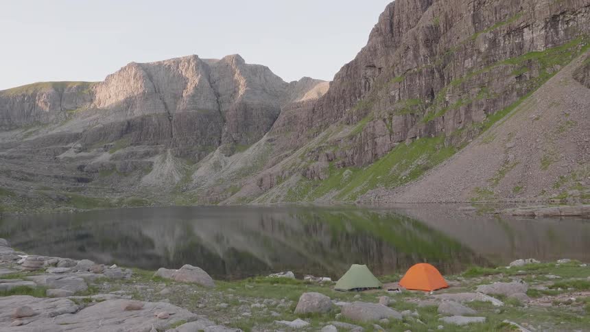 Colorful tents at the shores of a lake in the mountains