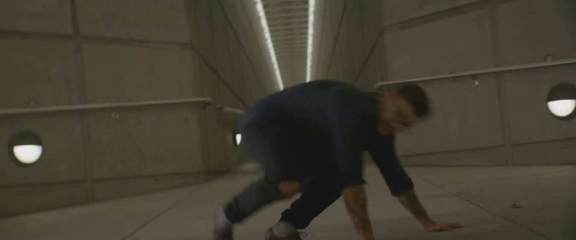 A male dancer break dancing in a tunnel