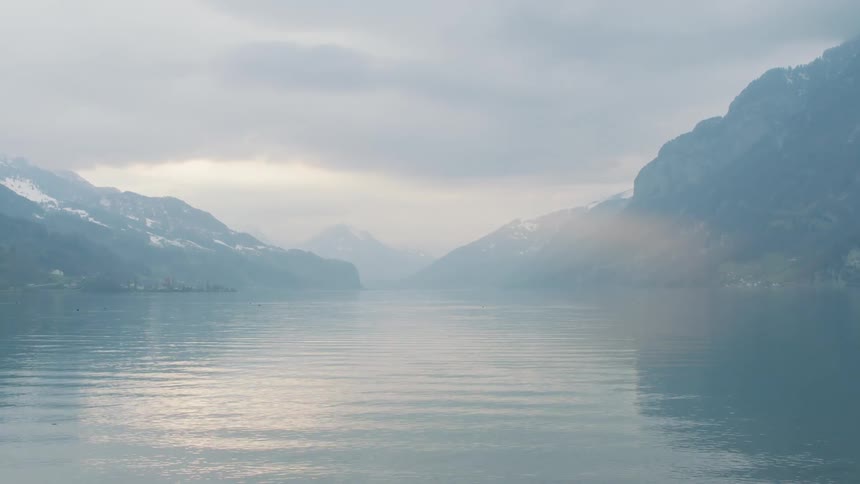 Mist over the calm lake surface in the mountains