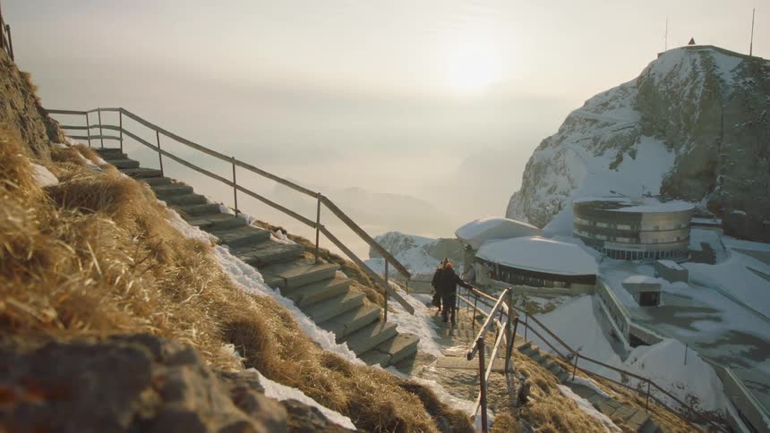 People walking down the stairs on the slopes of a ski complex in the mountains