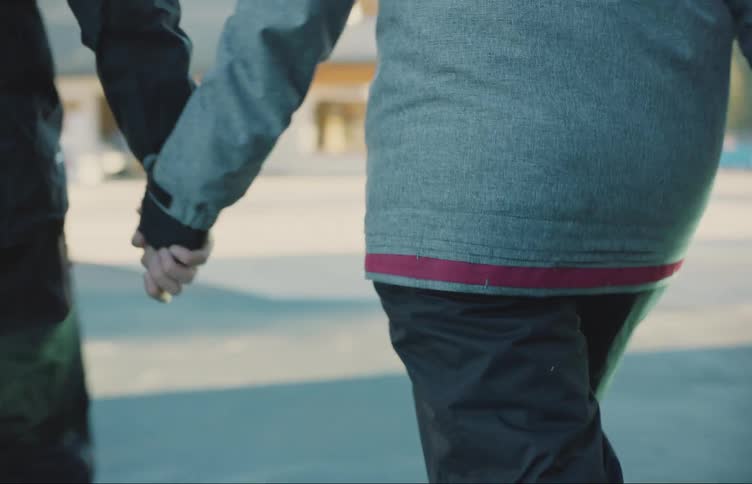Young couple walk holding hands