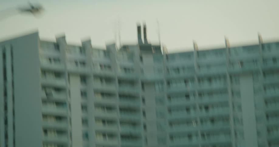 A large white building and cars driving by on a road