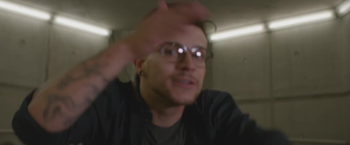 A man in an underground tunnel runs toward the camera and points
