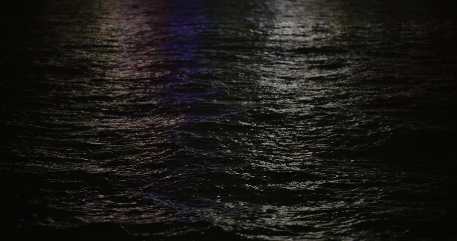 City buildings illuminating the body of water