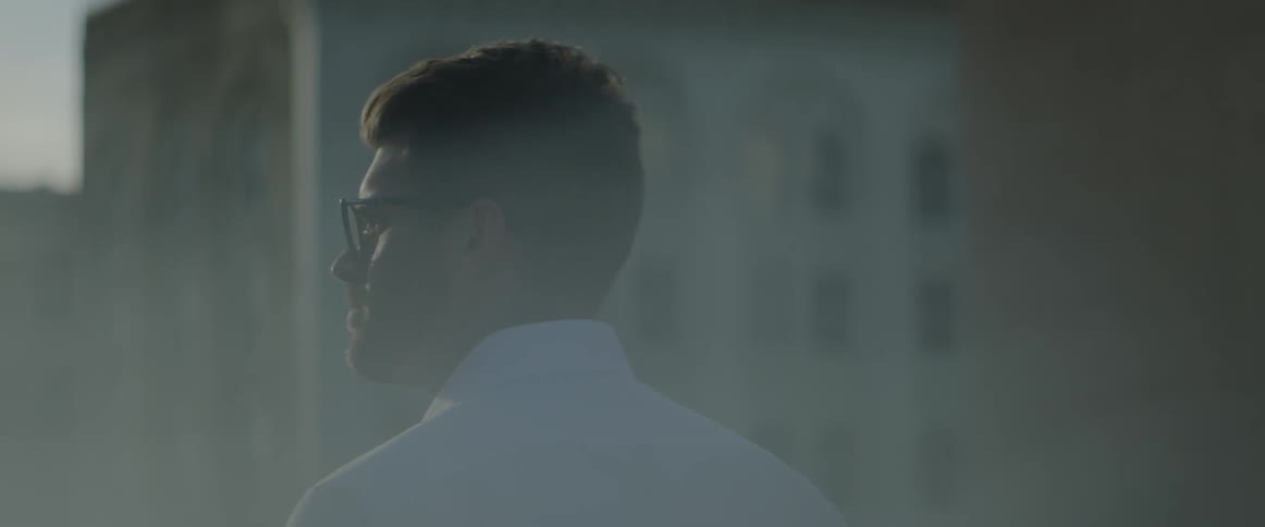 The sun shines down on a man standing outside