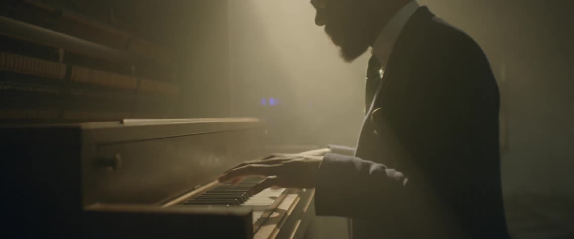 Pianist wearing sunglasses and a hat performing his art