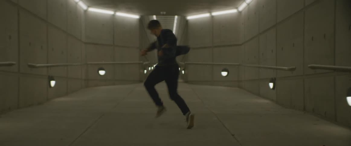 A man is dancing in a long hall