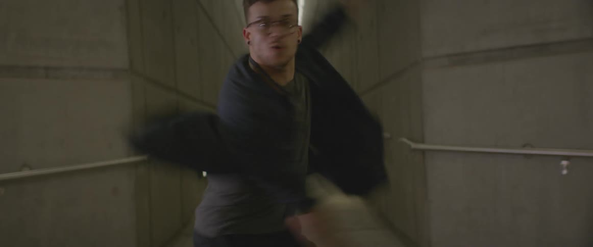 A man is twirling as he dances in a hall