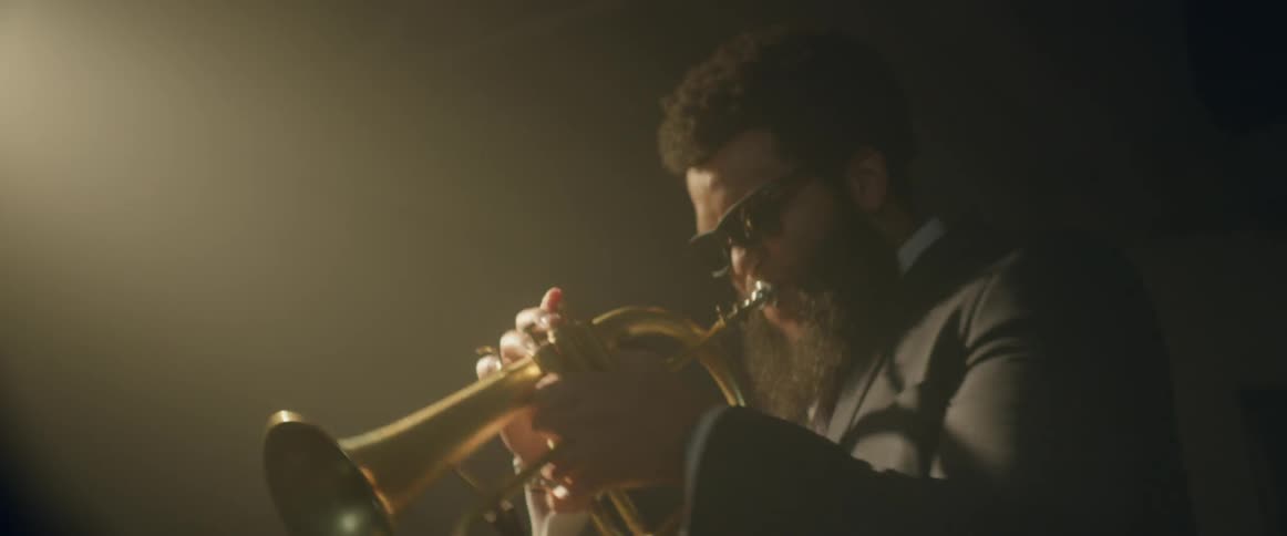 A man is energetically playing the tuba