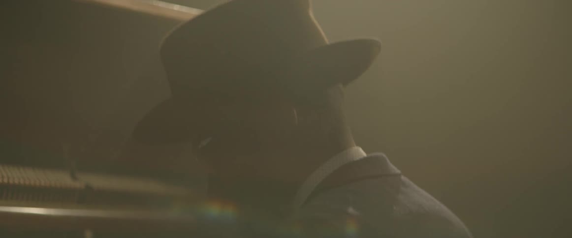 A man bops his head while playing a piano