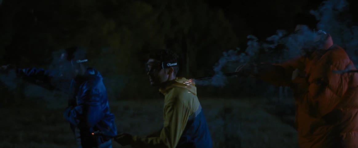 Friends in a battle with glowing wands in a field at night