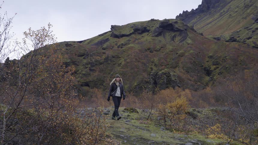 A young lady hiking downa mountain trail