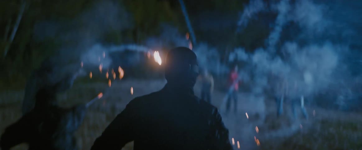 People in a battle with fireworks in a field at night