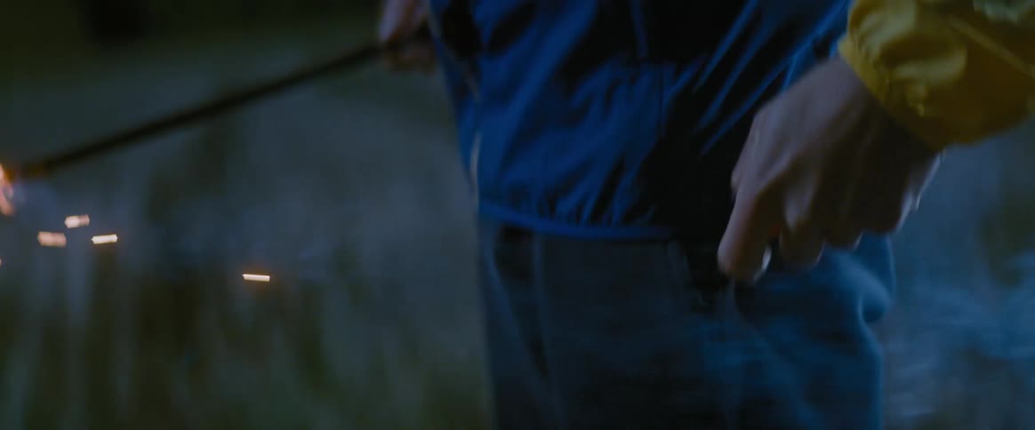 A man lights a sparkler at night