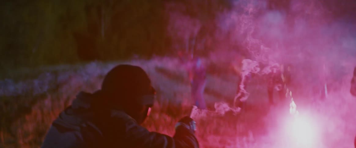 People setting off fireworks at each other in a field at night