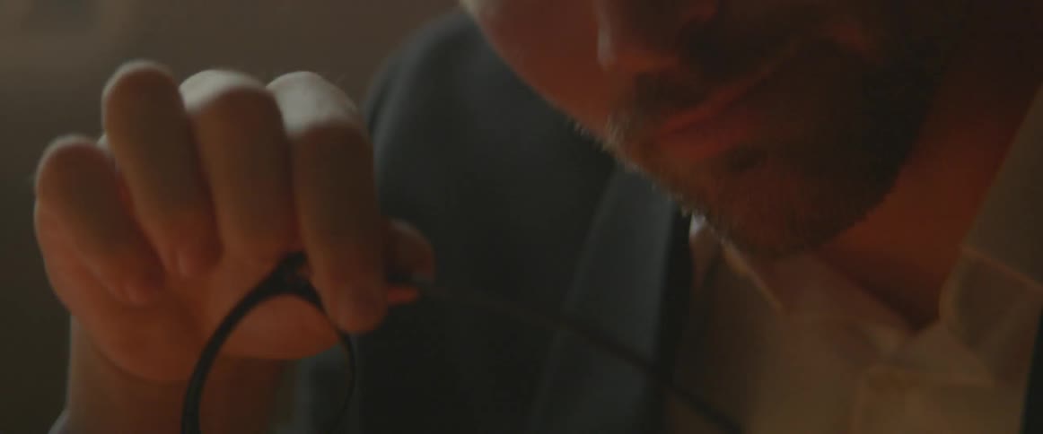 A man removing his glasses and wiping his brow