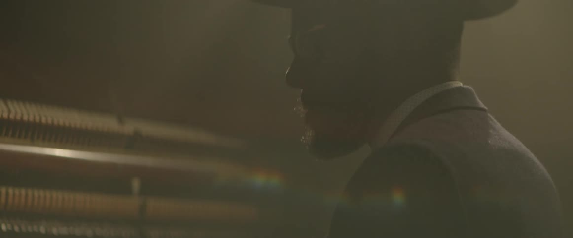 Drummer wearing a hat and sunglasses bobbing to the rhythm