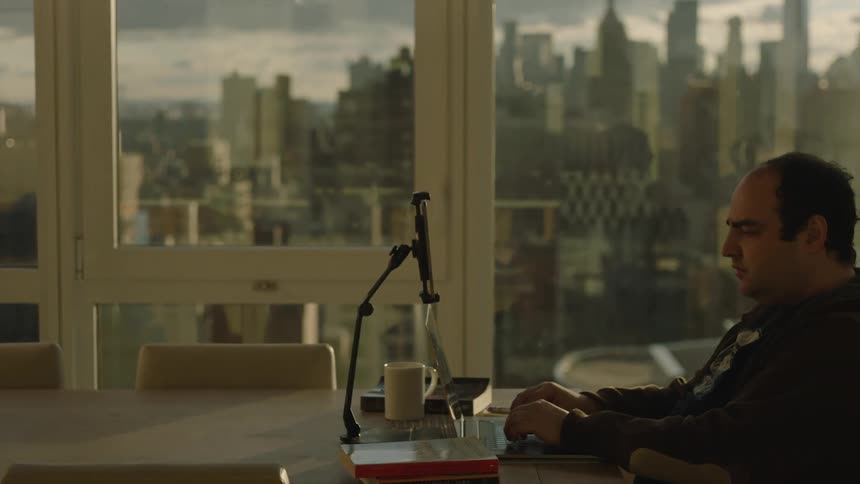 Man working from his office in the city at sunset
