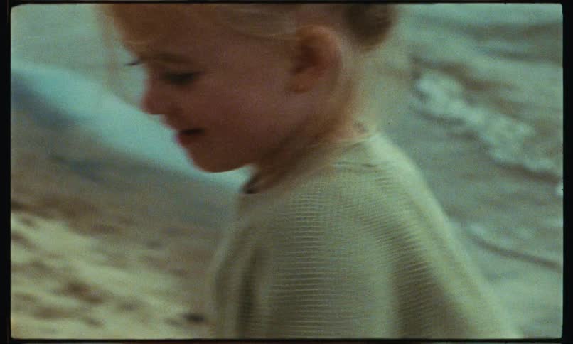 A child on the beach running from the waves