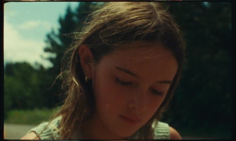 Closeup of a girls face holding a flower outdoors