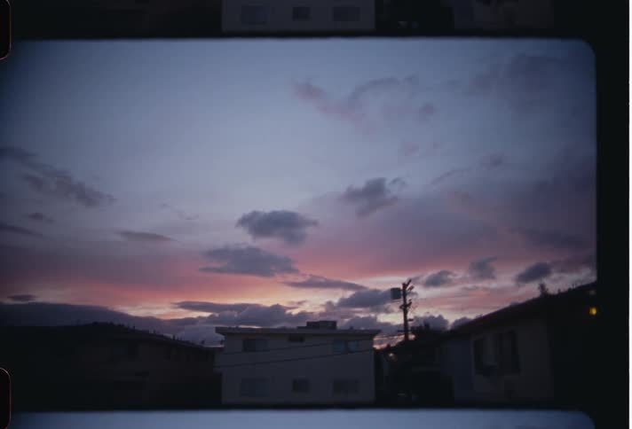 A house with several doors and the sky is orange due to the sunset