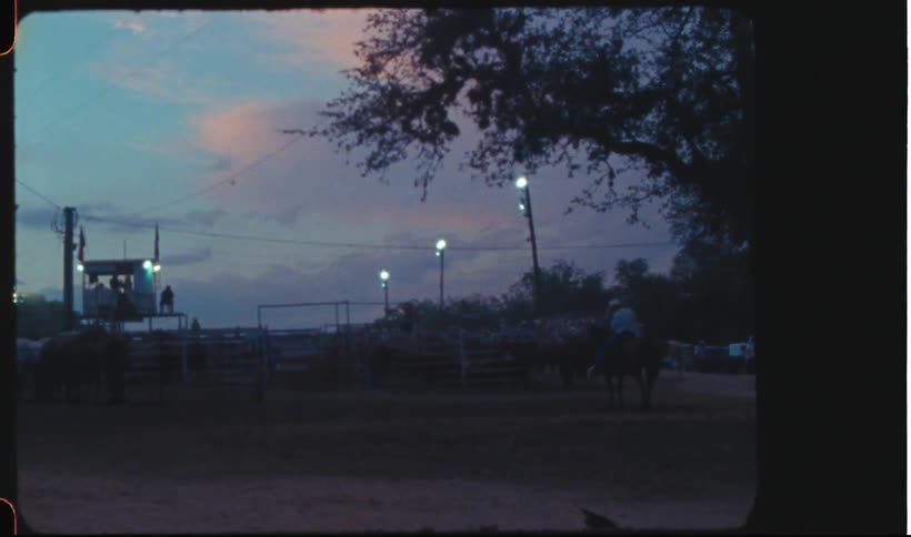 A rodeo scene at evening shot on vintage film