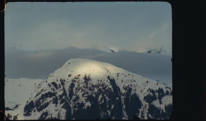 A snowy mountain peak under a cloudy sky