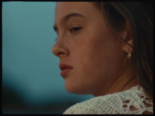 A young woman with her face turned to the side looking sad and pensive