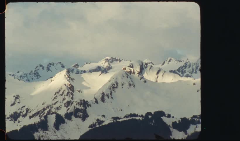 Snow covered mountain range under a cloudy sky