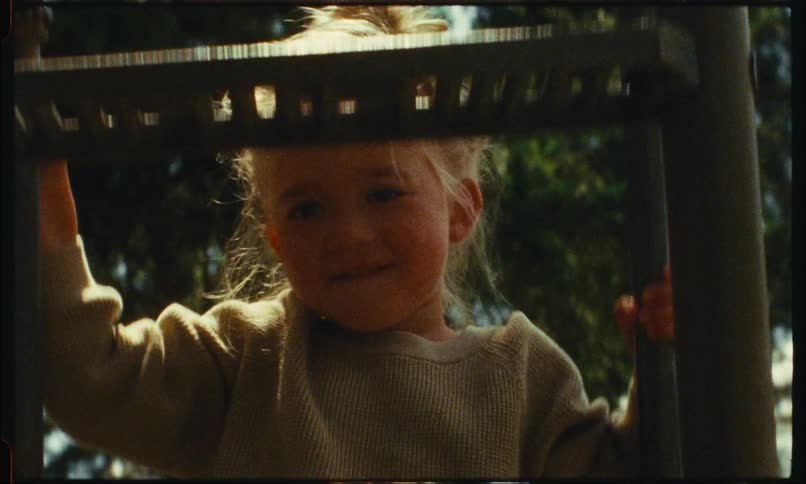 A little blonde girl is climbing an iron staircase