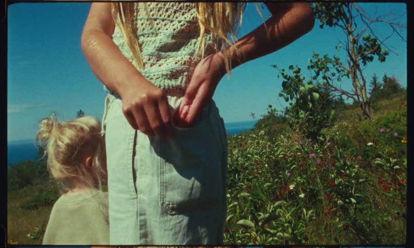A mother and daughter standing outside in a field