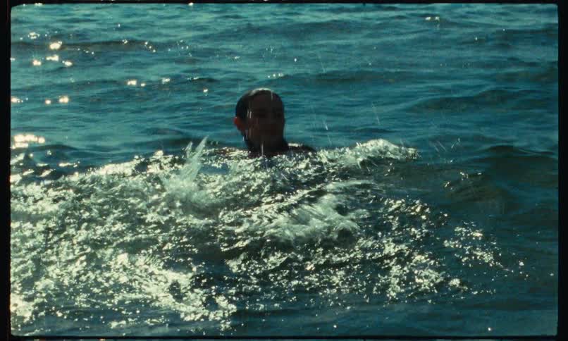 Young woman swimming on her back in the middle of the sea